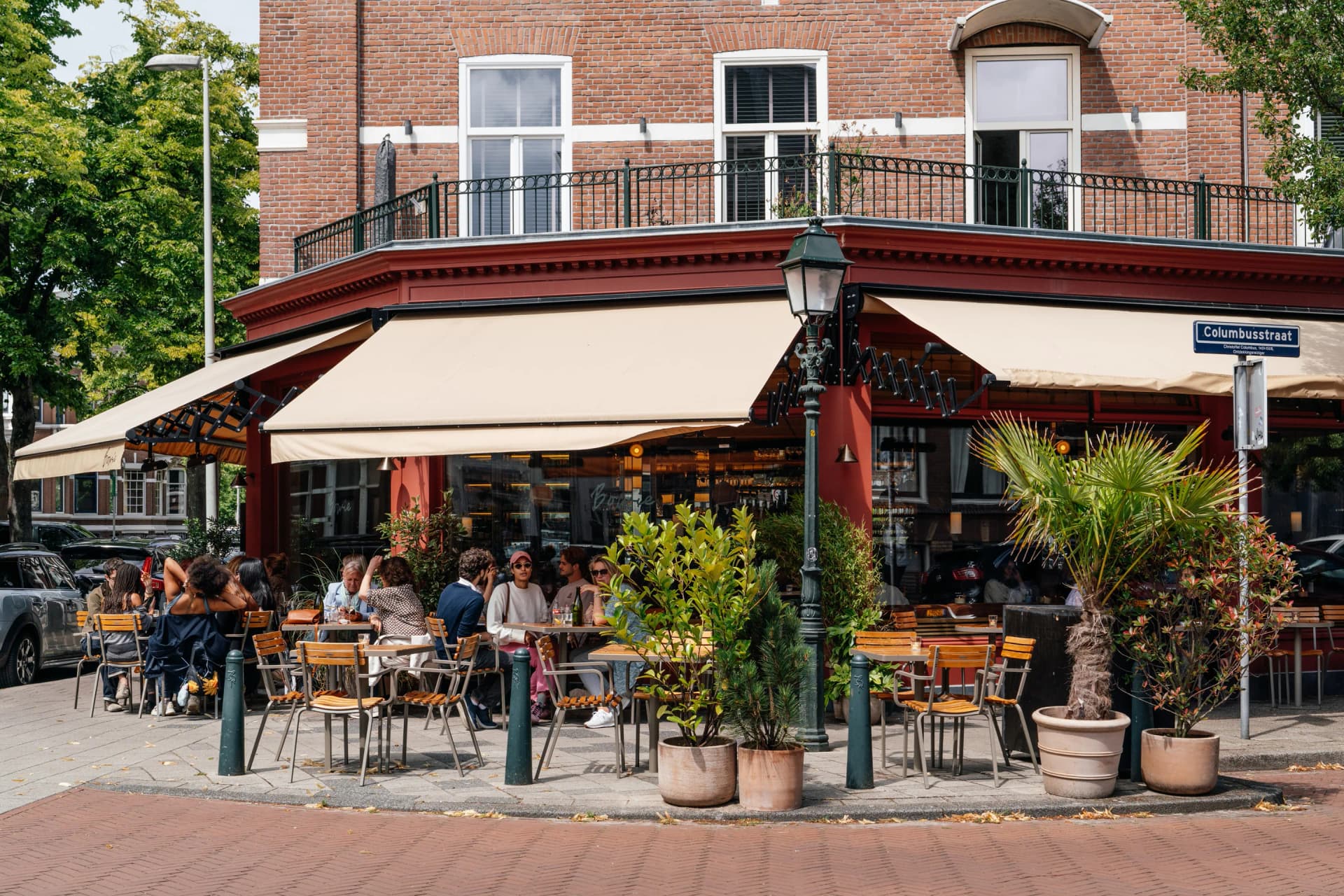 Terras van Bar Bowie op de hoek, met parasols en gasten