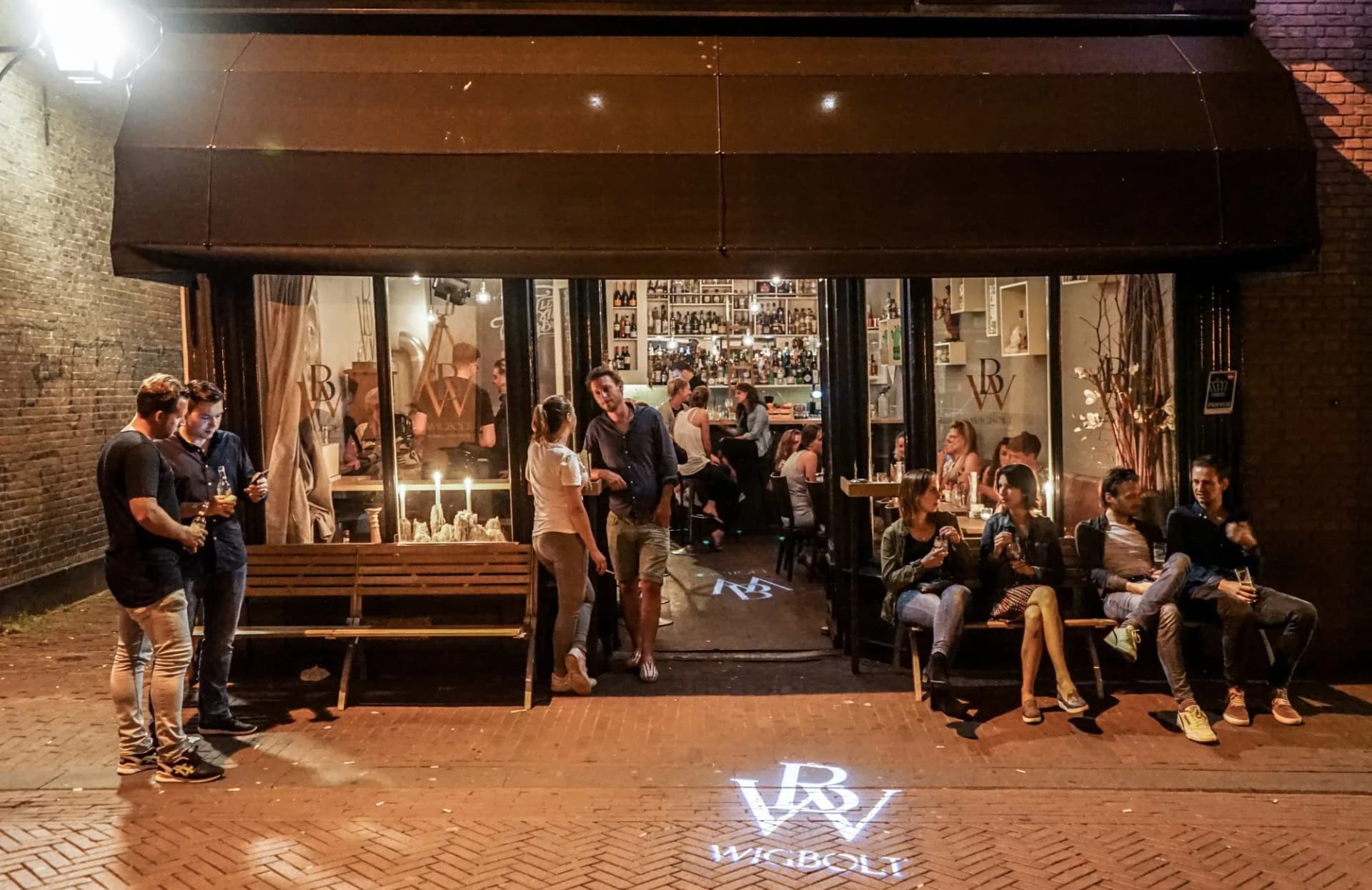 Gasten op het terras van Bar Wigbolt bij avond