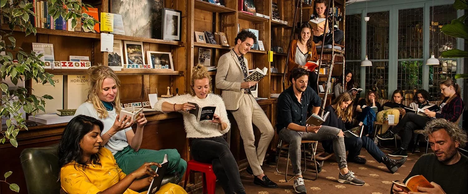 Gasten lezend tussen de boekenkasten bij Bookstor