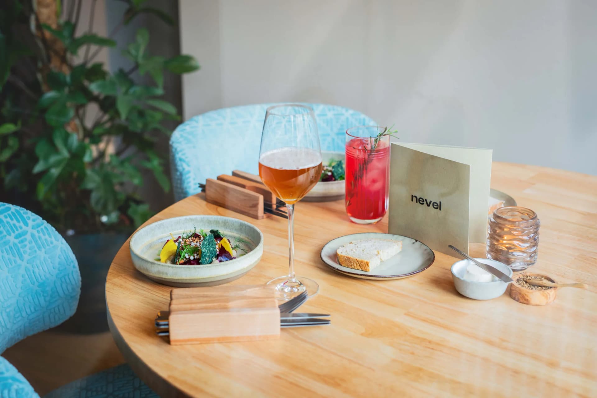 Gedekte tafel met wijn, cocktail en menukaart bij Nevel