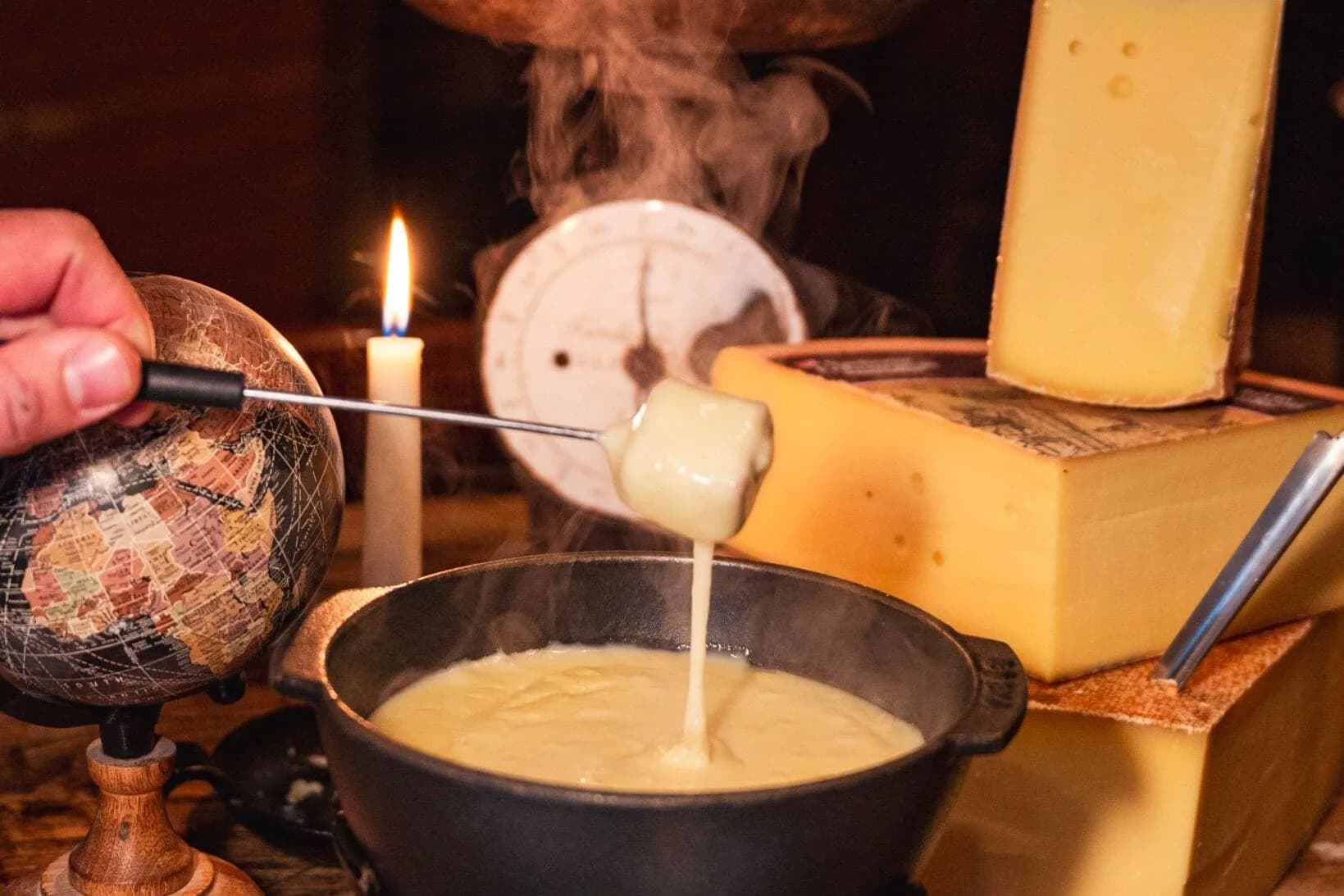 Kaasfondue met blokken kaas en een gedoopt stuk brood