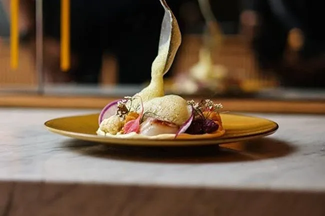 Chef werkt een gerecht af aan tafel bij Verlan