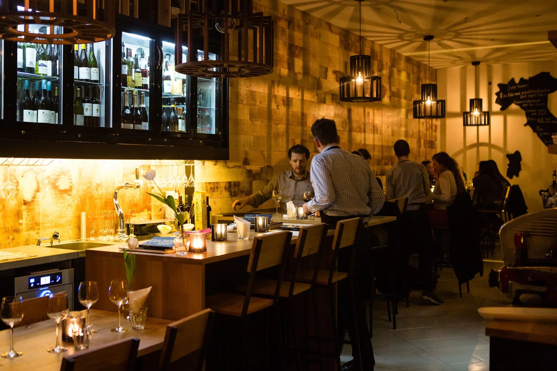 Bar met wijnkoeling en gasten bij Wijn bij Stijn